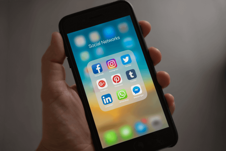 Hand hält Handy mit Social Media Icons